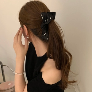 Barrette banane élégante en satin noir avec perles sur de longs cheveux bouclés