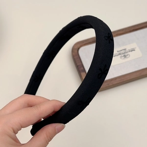 Classic black sponge headband with textured bow print and vintage high crown style