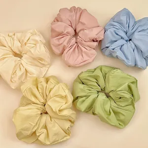 Lot de cinq chouchous géants en satin aux tons pastel comprenant beige et rose
