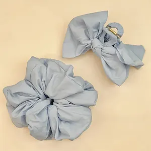 Détail du set pince à cheveux avec grand nœud bleu poudré et chouchou assorti texture mate