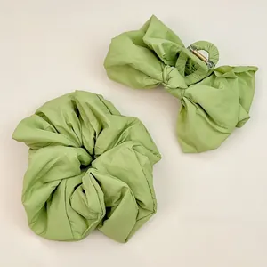 Détail de la pince à cheveux nœud et chouchou vert avocat en tissu plissé élégant
