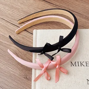 Sweet ribbon bow headbands in black and pink on rustic wooden background