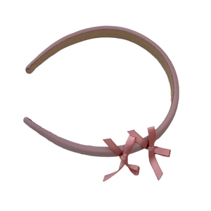 Elegant pink satin headband with delicate bow decorations on a clean white background
