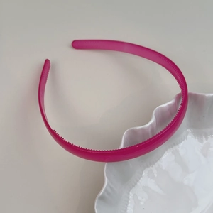Détail d'un serre-tête rose translucide avec dents antidérapantes et texture en résine