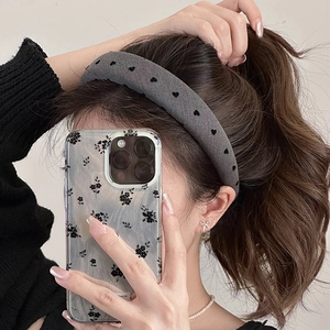 Close-up of wide grey sponge headband with black heart patterns and fabric texture