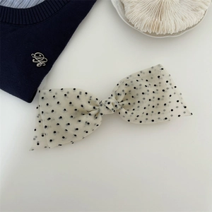 Close-up of a vintage black polka dot hair bow clip made of sheer organza fabric