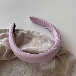 Vue détaillée du serre-tête rembourré lavande avec étiquette fait main et tissu doux