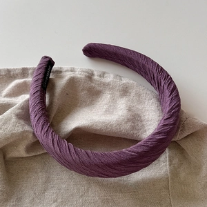 Détail de la texture plissée et de l'étiquette faite main sur le bandeau violet