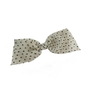 Vintage cream oversized bow hair clip with black polka dots on a white background