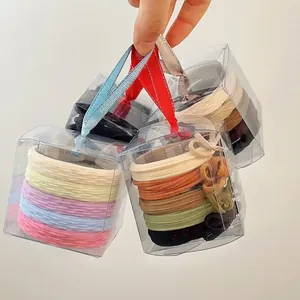 Set of colorful elastic hair ties in transparent gift boxes with silk ribbon accents