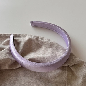 Vue détaillée du serre-tête rembourré violet lavande avec texture en similicuir sur lin