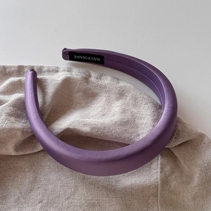 Détail de l'étiquette 'HAND MADE' à l'intérieur du serre-tête en satin violet élégant