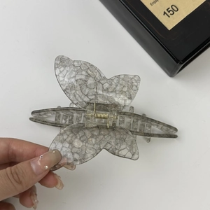 Detail of handmade acetate butterfly hair claw clip with grey marble pattern finish