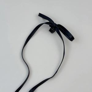 Pince à cheveux nɶud en cuir noir style ballet avec de longs rubans sur fond blanc