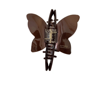 Elegant butterfly hair claw in brown acetate finish with gold branding for updo hairstyles