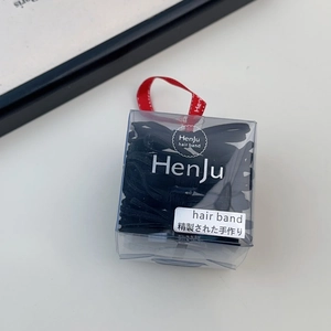 Detail of black elastic hair bands in transparent box with red ribbon and Japanese label