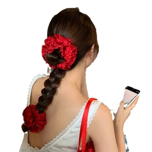 Chouchou géant en satin rouge pour chignons avec texture de soie plissée brillante