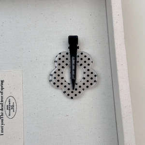 Dettaglio di un fermaglio per capelli a fiore a pois con clip a becco d'anatra in metallo