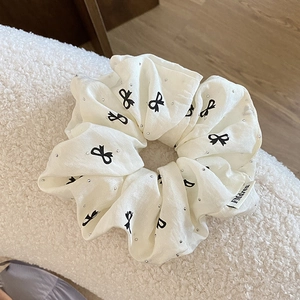 Detail von cremefarbenem Scrunchie mit Schmetterlingsdruck und Strasssteinen