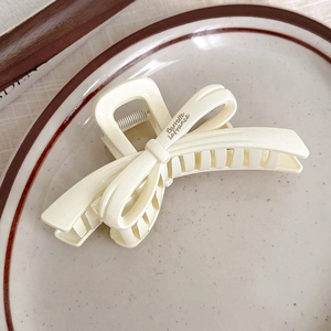 Détail d'une pince à cheveux crème avec texte Barrette La France sur une assiette chic