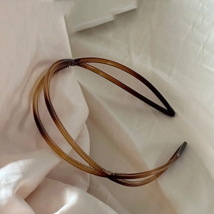 Close-up of amber brown double-layer crisscross headband with inner non-slip teeth detail