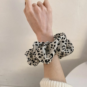 Detail of oversized leopard print mesh hair scrunchie worn on wrist for size scale