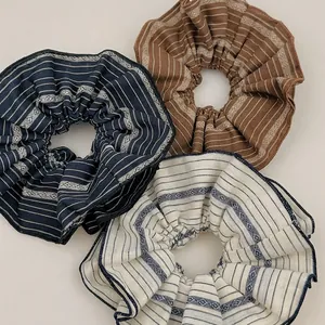 Three-piece retro striped fabric scrunchie set in navy, brown and beige tones