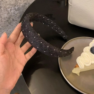 Gros plan détaillé du serre-tête en denim noir orné de strass brillants et élégants