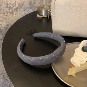 Vue détaillée du serre-tête rembourré en denim à pois blancs sur une table