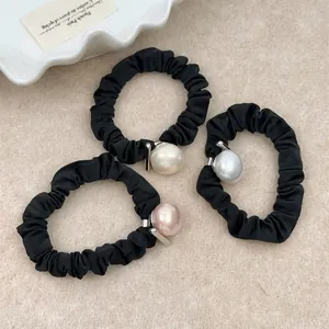 Three-piece black fabric hair ties set with glossy faux pearls in cream, grey, and pink