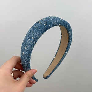 Close-up of a wide blue denim headband with sparkling silver rhinestones for women