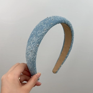 Detailed view of light blue denim headband with sparkling silver rhinestones and camel lining