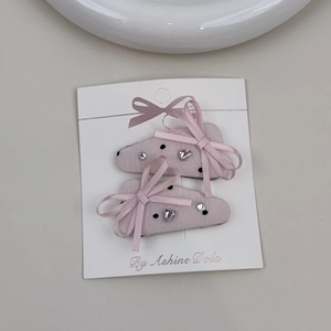 Pair of pink satin bow hair clips with black polka dots and sparkling rhinestones