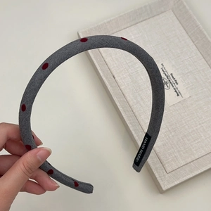 Detail showing grey knit polka dot headband with black Hand Made interior label