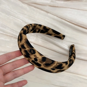 Close-up of handmade leopard print headband with premium fabric texture and label