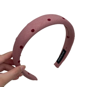 Pink polka dot sponge headband with high-top design and handmade label for women