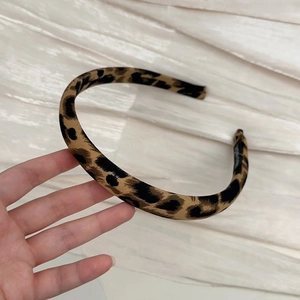 Close-up of leopard print fabric headband showing high-quality texture and inner label
