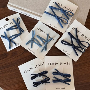 Haarspelden van spijkerstof met strik in diverse blauwtinten op vintage houten achtergrond