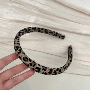 Detail of handmade leopard print fabric headband featuring classic brown spotted texture