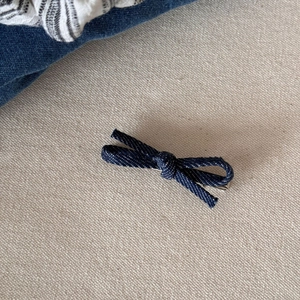 Gedetailleerde textuur van de blauwe denim strik haarklem met zilveren metalen clip