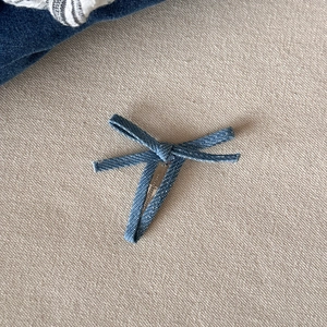 Macro-opname van de blauwe denim haarstrik met twill stof en zilveren metalen krokodillenklem