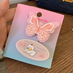 Détail d'une pince à cheveux papillon rose et épingle caniche sur carte faite main