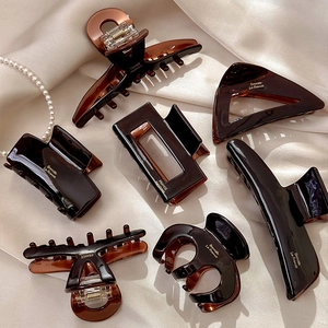 Elegant tortoiseshell acetate hair claws in various geometric shapes on silk fabric
