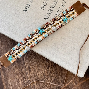 Bohemian braided headband and waist chain with starfish and seashell charms on wood
