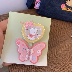 Détail de barrettes papillon mignonnes avec motifs de cœur, chiot et nœuds roses