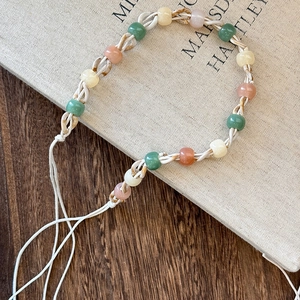 Detail of bohemian hand-woven braided headband with colorful beads on a book