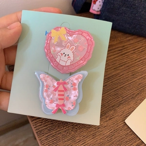 Détail de la pince à cheveux cœur rose motif lapin et pince papillon florale bleue en lot