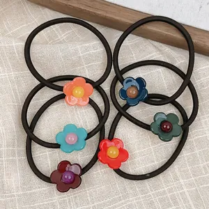 Set mit sechs bunten Acetat-Blumen-Haargummis mit elastischen Bändern auf Leinen