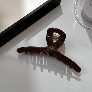 Detail of amber acetate hair claw clip with gold France Handmade lettering and strong metal spring