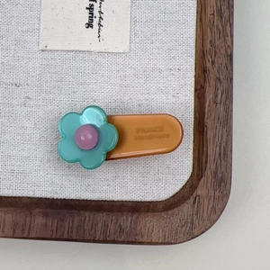 Handmade acetate flower hair clip with contrasting colors and golden France logo